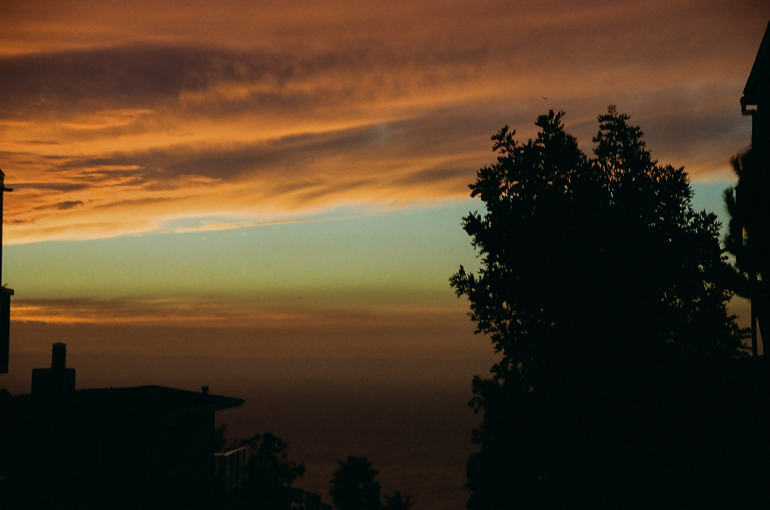 Sky and clouds turn an orange-pink color as the sun sets in Laguna Beach.