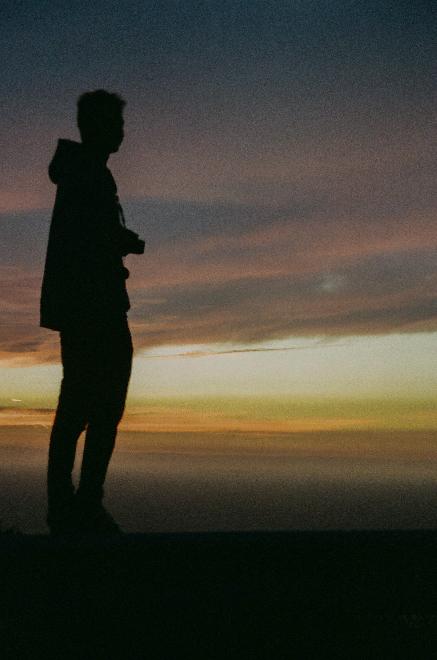 Friend's silhouette captured as he stands in front of the sun setting over the Pacific Ocean.