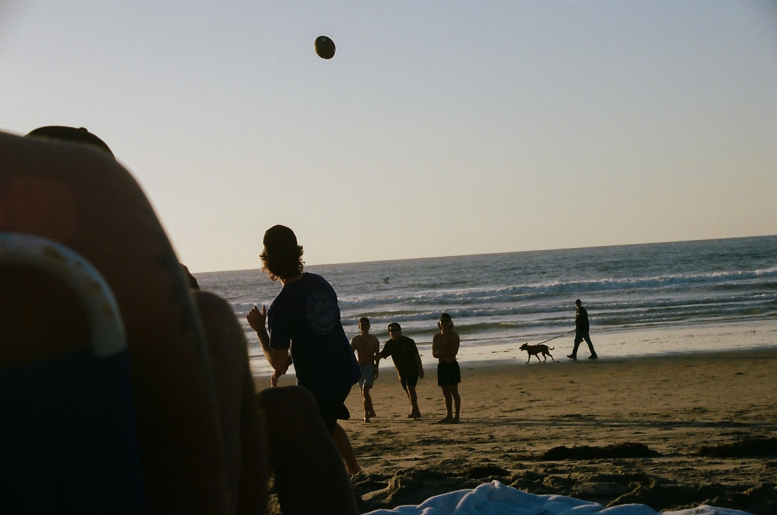 Friend throws a football to three others patiently waiting to catch it.