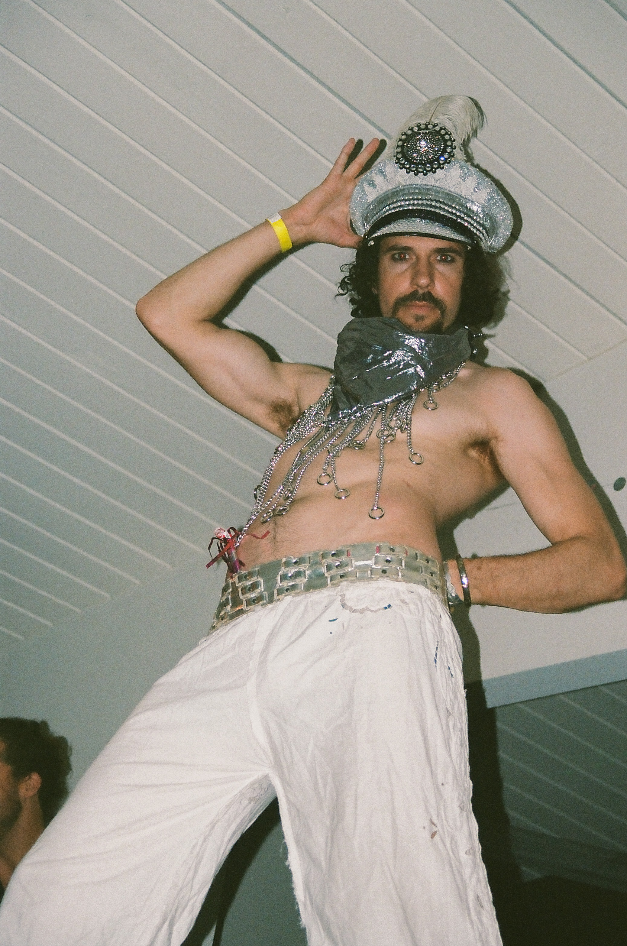 Man on stilts poses for a picture on the dancefloor.