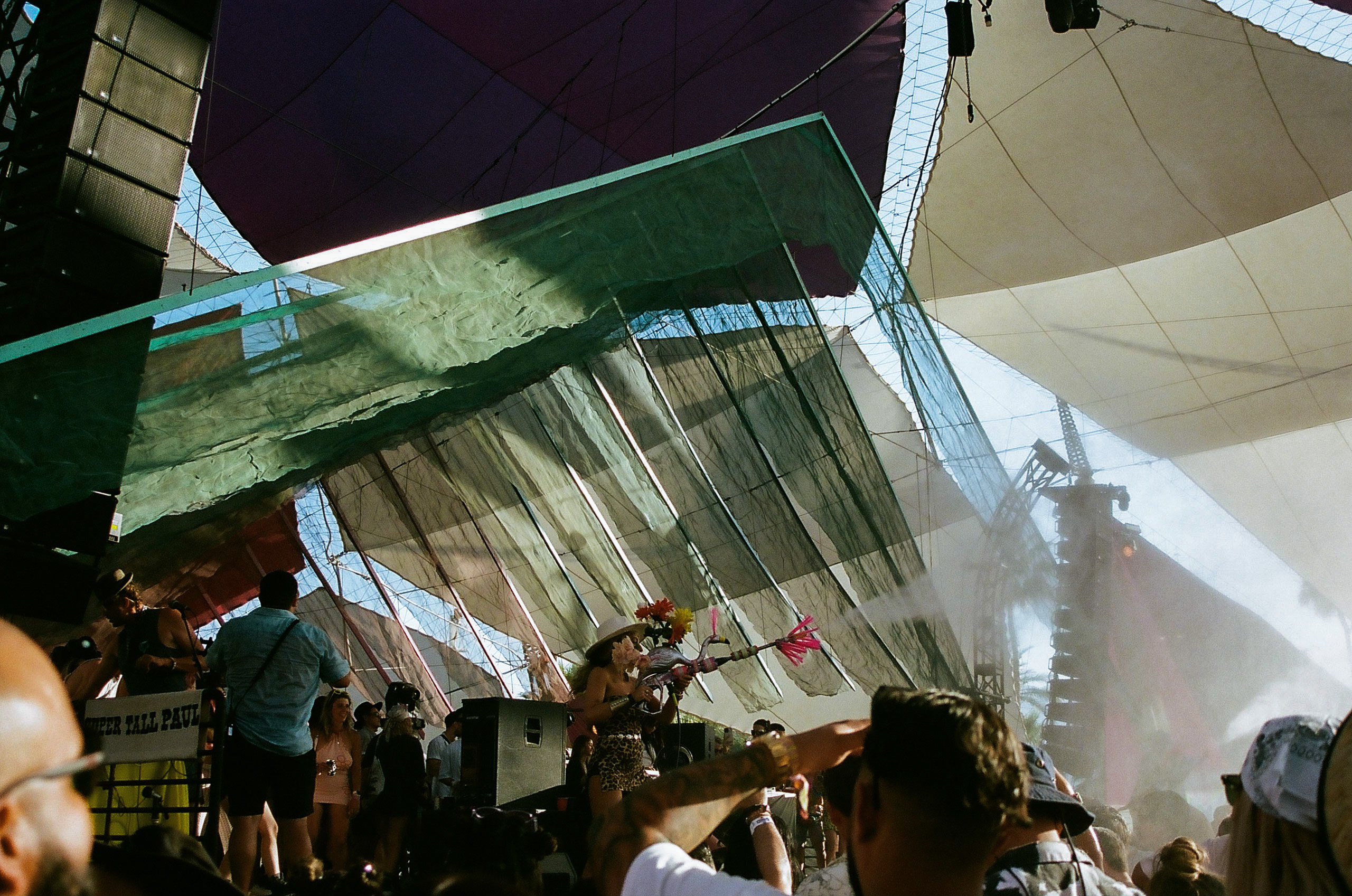 Woman uses mister to spray and cool down the crowd watching performances at the DoLaB at Coachella Valley Music and Arts Festival 2022.