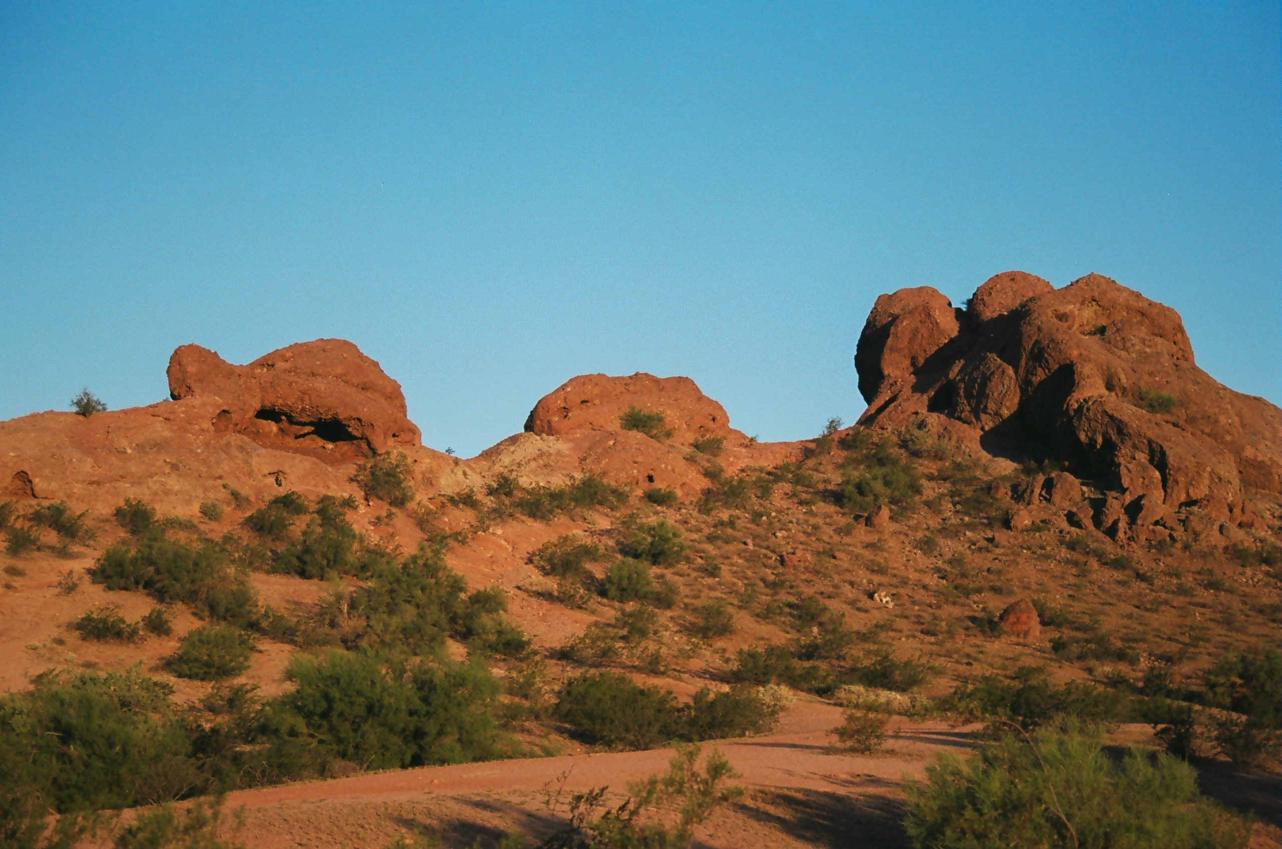 Golden hour lighting from the sunset cause turn buttes in Papago Park a vibrant orange color.